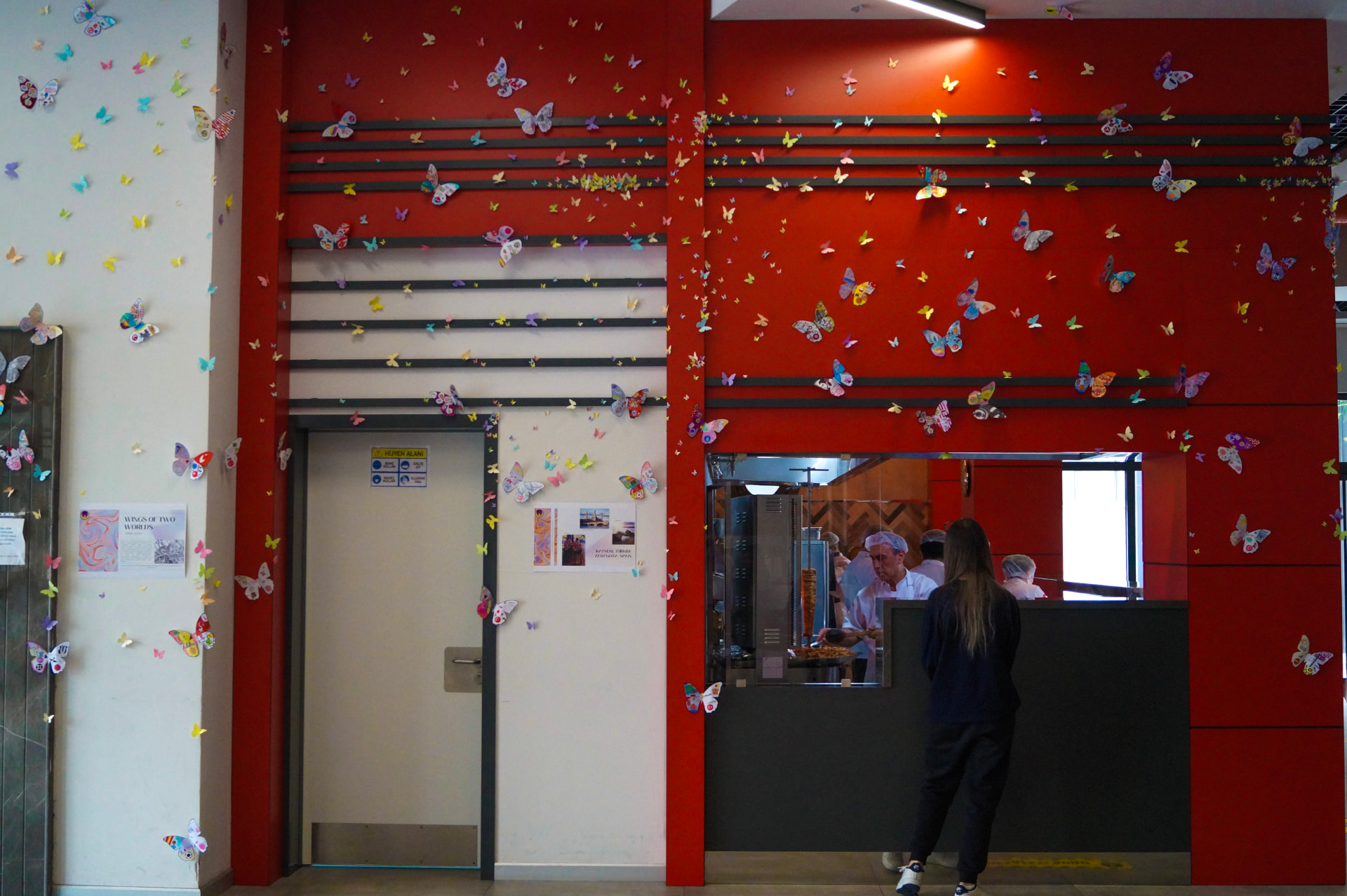 A red and white school hall entirely covered with student-made paper butterflies